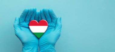 Doktorlar ellerinde Macaristan bayrağı taşıyan ameliyat eldivenleri takıyor.