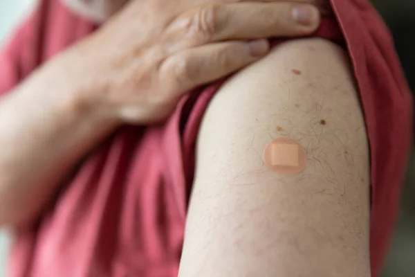 Homem caucasiano com um gesso no braço após uma injeção de vacinação — Fotografia de Stock