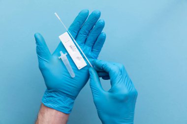 Mavi eldivenli doktor yan akış kovid 19 test kiti kullanıyor.