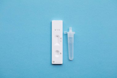 Mavi arka planda Coronavirus lateral akış ev test kiti