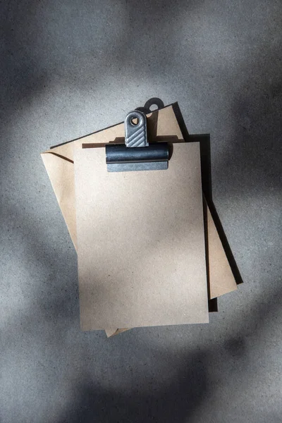 Prázdná hnědá pozvánka nebo pohlednice s obálkou pod tečkovaným slunečním světlem — Stock fotografie