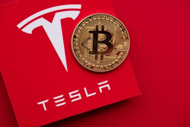LONDON, İngiltere - Haziran 2021: Tesla elektrikli araç logosu üzerindeki Bitcoin kripto para birimi