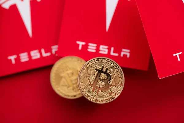 LONDON, UK - June 2021: Bitcoin cryptocurrency on a Tesla electric vehicle logo — Stock Photo, Image