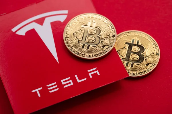 LONDON, UK - June 2021: Bitcoin cryptocurrency on a Tesla electric vehicle logo — Stock Photo, Image