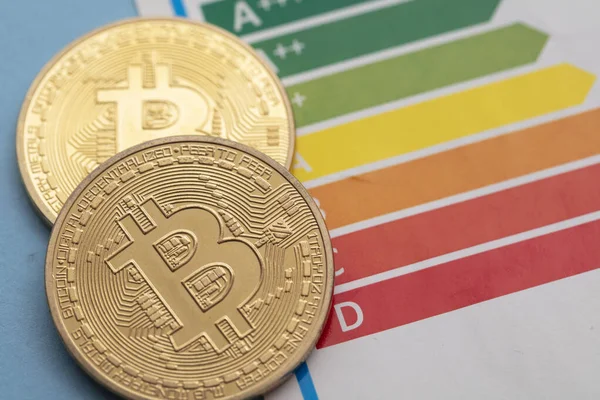 Bitcoin criptomoneda moneda de oro con una tabla de calificación de eficiencia energética —  Fotos de Stock