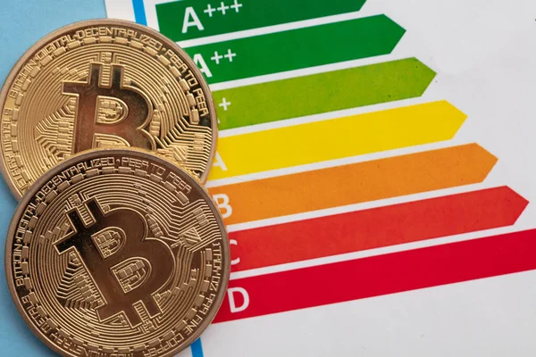 Bitcoin criptomoneda moneda de oro con una tabla de calificación de eficiencia energética —  Fotos de Stock