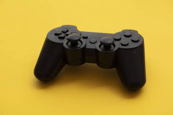 Contrôleur de jeu vidéo noir sur un fond jaune vif — Photo