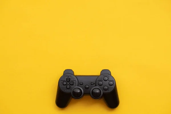 Controlador de vídeo game preto em um fundo amarelo brilhante — Fotografia de Stock