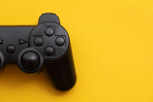 Controlador de videojuegos negro sobre un fondo amarillo brillante —  Fotos de Stock