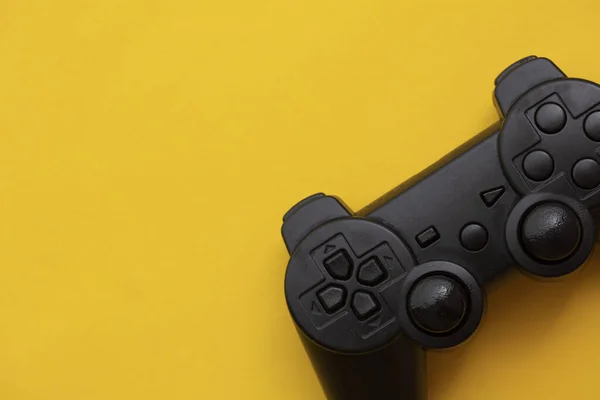 Controlador de vídeo game preto em um fundo amarelo brilhante — Fotografia de Stock