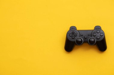 Parlak sarı arkaplanda siyah video oyunu denetleyici