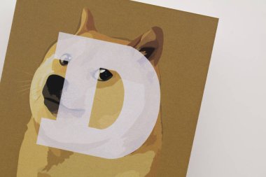 LONDON, UK - June 2021: Doge or dogecoin cryptocurrency logo on paper