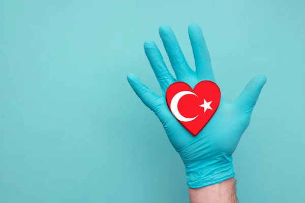 Turkey medical health heart. Nurse hand holding country heart flag