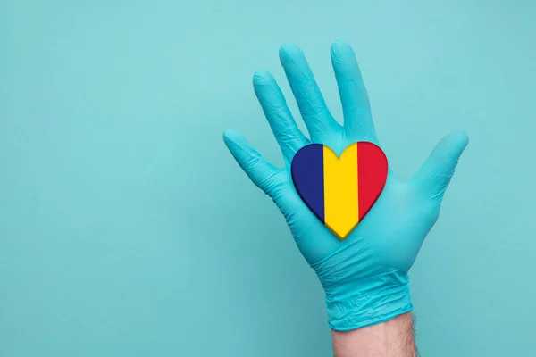 Romania medical health heart. Nurse hand holding country heart flag