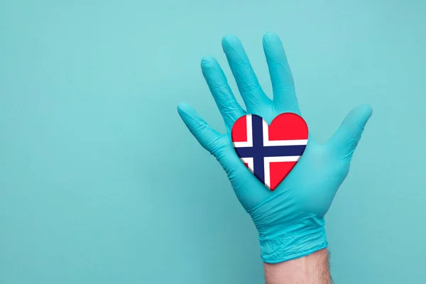 Norway medical health heart. Nurse hand holding country heart flag