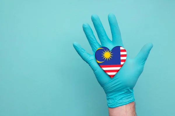 Malezyjskie medyczne serce. Pielęgniarka trzyma flagę kraju serca — Zdjęcie stockowe