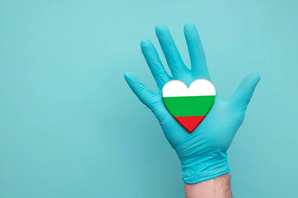 Bulgaria kesehatan jantung. Perawat tangan memegang bendera jantung negara — Stok Foto