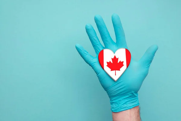 Canada medical health heart. Nurse hand holding country heart flag