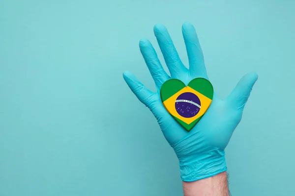 Brazilië medische gezondheid hart. Verpleegster hand holding land hart vlag — Stockfoto