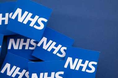 LONDON, İngiltere - Temmuz 2021: Mavi arka planda NHS Ulusal Sağlık Hizmetleri logosu