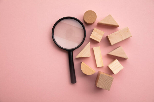 Magnifying glass with a selection of different shaped wooden blocks