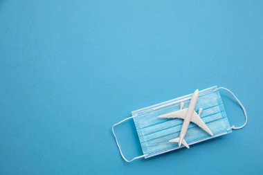 Hava yolculuğunun arka planı. Koronavirüs koruyucu maskeli bir uçak.