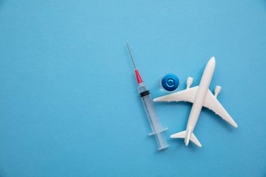 Hava yolculuğunun arka planı. Koronavirüs aşısı iğnesi olan bir uçak.