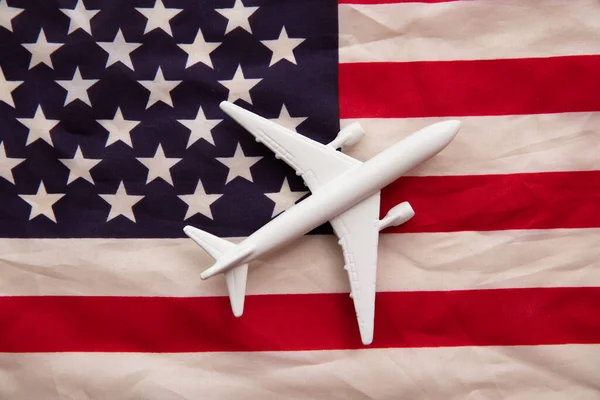 Tło lotu Stanów Zjednoczonych. Zabawka samolotowa na starcie i flaga w paski — Zdjęcie stockowe