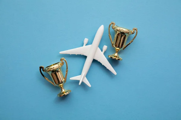Nagrody za podróże samolotem. Zadowolenie biznesu lotniczego. Samolot zabawki ze złotym trofeum — Zdjęcie stockowe