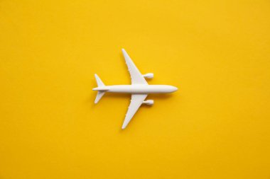 Yazın sarı arka planda beyaz yolcu uçağı. Seyahat ve tatil geçmişi