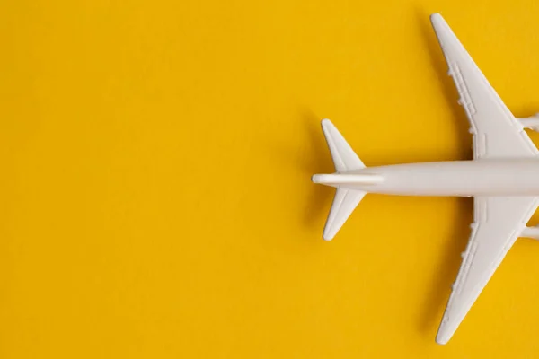 Avión de pasajeros blanco sobre fondo amarillo veraniego. Viajes y vacaciones fondo —  Fotos de Stock