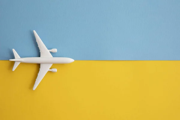 Надворі лежала квартира білого пасажирського літака на яскравому синьо-жовтому фоні — стокове фото