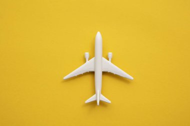 Yazın sarı arka planda beyaz yolcu uçağı. Seyahat ve tatil geçmişi