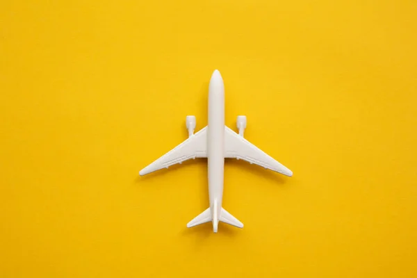 Avión de pasajeros blanco sobre fondo amarillo veraniego. Viajes y vacaciones fondo —  Fotos de Stock