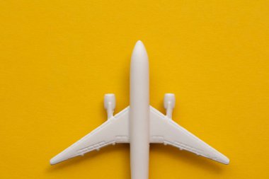 Yazın sarı arka planda beyaz yolcu uçağı. Seyahat ve tatil geçmişi