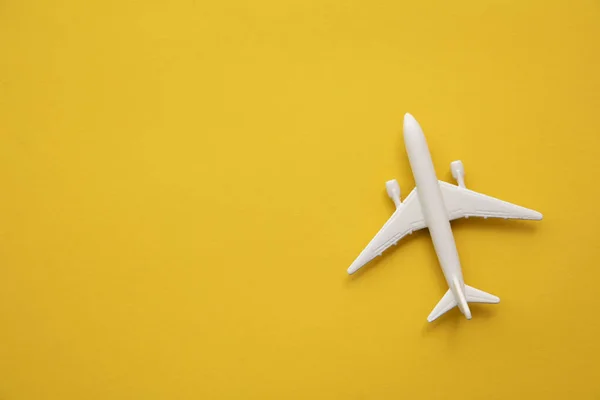 Avión de pasajeros blanco sobre fondo amarillo veraniego. Viajes y vacaciones fondo —  Fotos de Stock