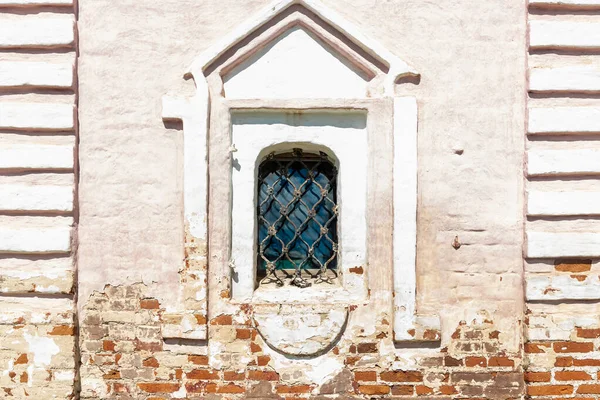Arch window with white frame and grid in historical building