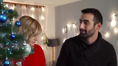 Bir çift oturma odasında Noel ağacı süslemekten zevk alıyor. Tatil hazırlığı.