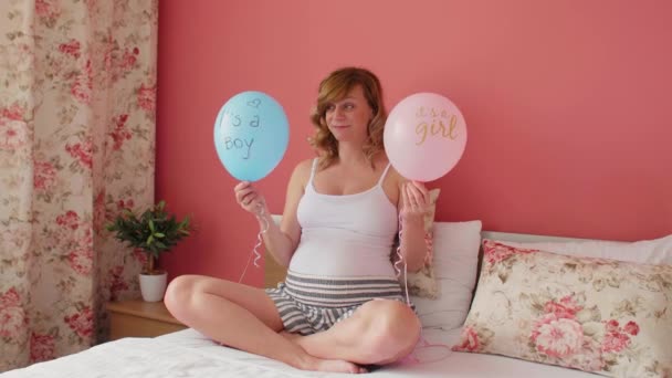 Gülen Mutlu Hamile Beyaz Bir Kadın Elinde Iki Balonla Yatakta — Stok video