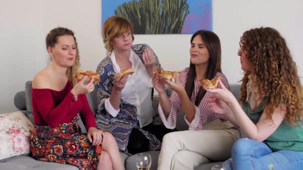 Quatro Amigas Sorridentes Conversando Sentadas Sofá Sala Estar Enquanto Comem — Vídeo de Stock