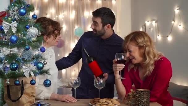 Dostlar Noel Ağacında Adam Şarap Şişesini Açıyor Tatil Hazırlığı Kutlaması — Stok video