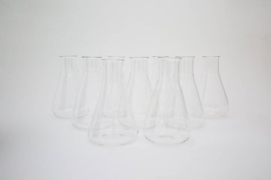 Beyaz arka planda izole edilmiş bir grup bilimsel cam Erlenmeyer şişesi.