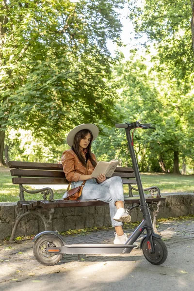 Молода Красива Жінка Капелюхом Сидить Лавці Парку Читаючи Книгу Електричний — стокове фото