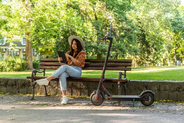 Eine Junge Frau Mit Hut Sitzt Auf Einer Parkbank Und — Stockfoto