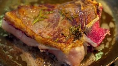 Mutfaktaki ızgara tepsisinde et pişirirken, şef eti nazikçe çevirir ve hazır olup olmadığını kontrol eder..