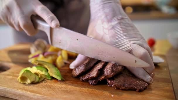 Close Chef Cutting Roasted Meat Wooden Kitchen Board Potatoes Avocados — Stock Video