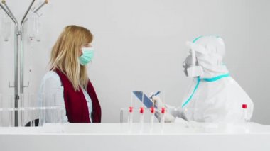 COVID-19 testi yapan bir tıp çalışanı hastanedeki kadın hastadan burun örneği Coronavirus için PCR testi, test kiti kullanan bir doktor..
