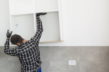 Marangoz, yeni monte edilen mutfak raflarını....