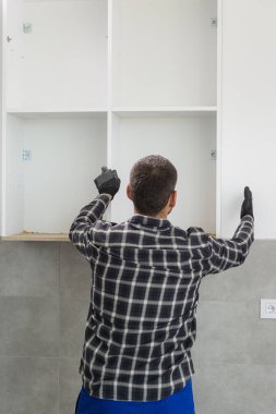 Marangoz, yeni monte edilen mutfak raflarını....