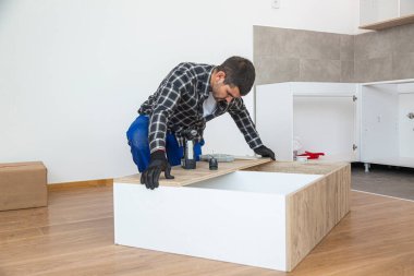 Marangoz mutfak rafının montajını bitiriyor..